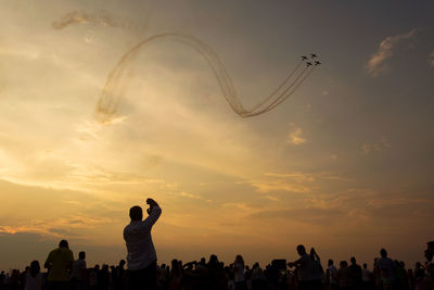 People on field against cloudy sky