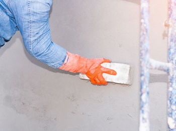 Low section of man standing on floor against wall