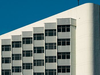 Low angle view of modern building against clear blue sky