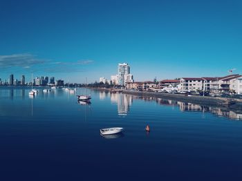 Sailboats in sea against clear blue sky