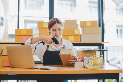 Businesswoman using laptop while sitting on table