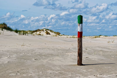 Wooden posts on beach against sky