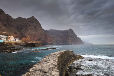 Scenic view of sea and mountains against sky