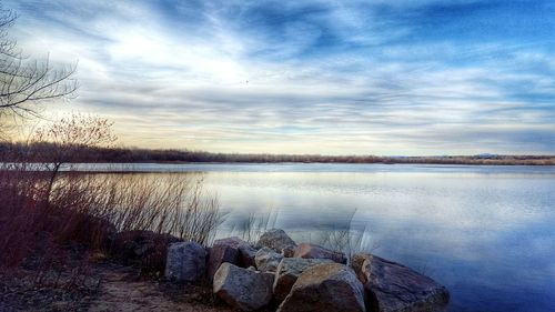 Scenic view of lake against cloudy sky