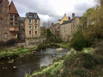 Buildings by the canal in the city against sky