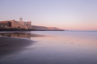 Views of alfredo kraus auditorium from las canteras beach at sunrise in las palmas de gran canaria.