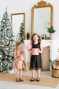 Kids opening xmas presents. children under christmas tree with gift boxes. decorated living room