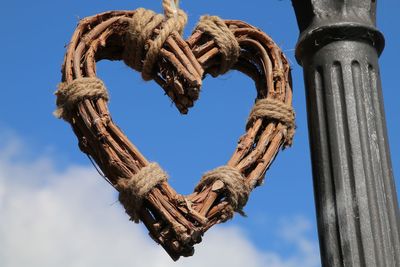 Low angle view of rope tied to pole against sky
