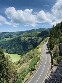 High angle view of road amidst field against sky