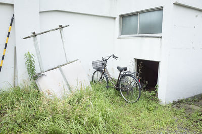Bicycle outside house on field against building