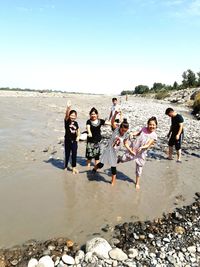 People enjoying at beach against sky