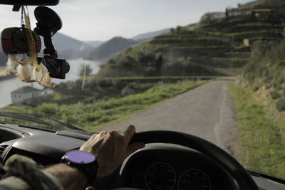 Rear view of man driving car on road