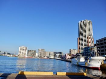 Modern buildings in city against clear blue sky