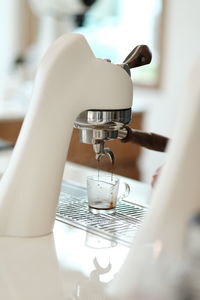 Close-up of hand holding faucet at home