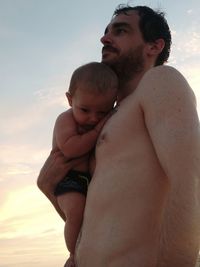 Father with baby against sky