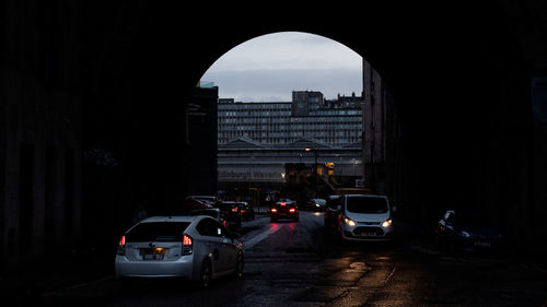 Traffic on road amidst buildings in city against sky