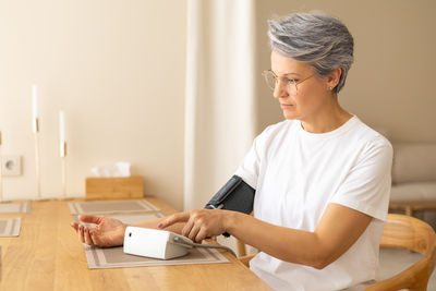 Side view of man using digital tablet at home
