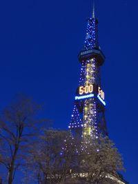 Low angle view of illuminated building against blue sky