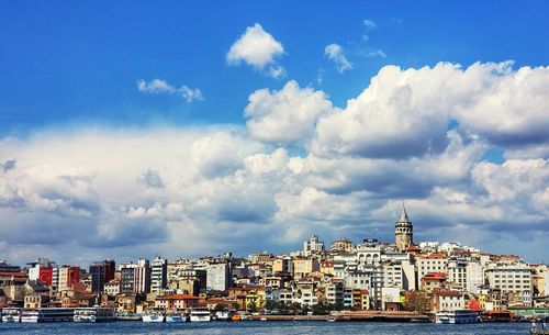 Buildings by sea against sky