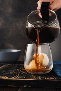 Close-up of hand pouring coffee in cup