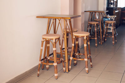 High angle view of empty chairs and table against wall