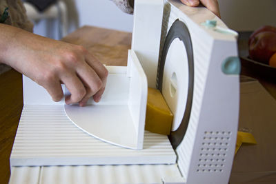 Close-up of woman holding machinery on table