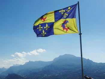 Low angle view of flag against blue sky