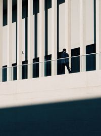 Side view of man standing against building