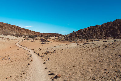 Scenic view of desert against clear blue sky