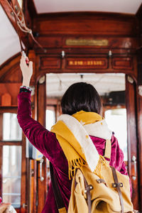 Rear view of woman holding umbrella