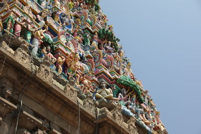 Low angle view of statues on building against sky