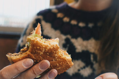 Midsection of woman holding burger