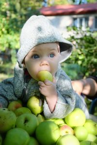 Cute baby eating apple outdoors
