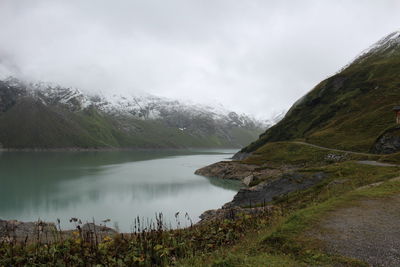 Scenic view of calm lake against cloudy sky