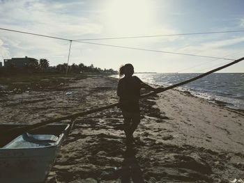 Rear view of man standing on beach