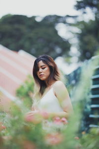 Portrait of woman standing against plants