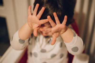 Close-up of child covering eyes