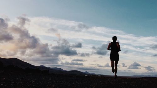 Rear view of man running against sky