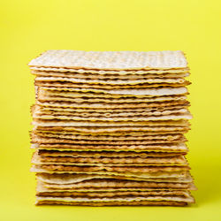 Close-up of stack of firewood against yellow background