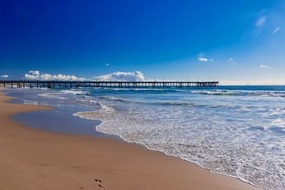 Scenic view of beach against blue sky