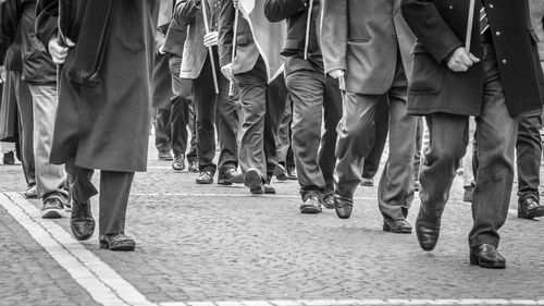 Low section of people walking in row on street