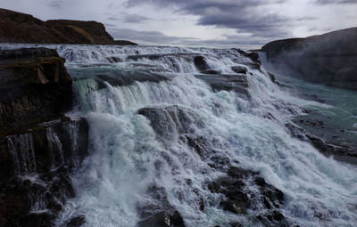 Scenic view of waterfall against sky