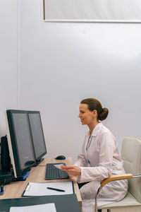 Side view of young man using laptop while sitting at home