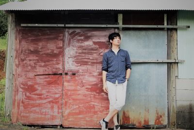 Teenage boy standing against building