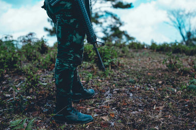 Low section of soldier standing by plants