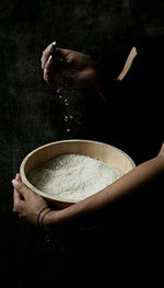 Midsection of person preparing food against black background