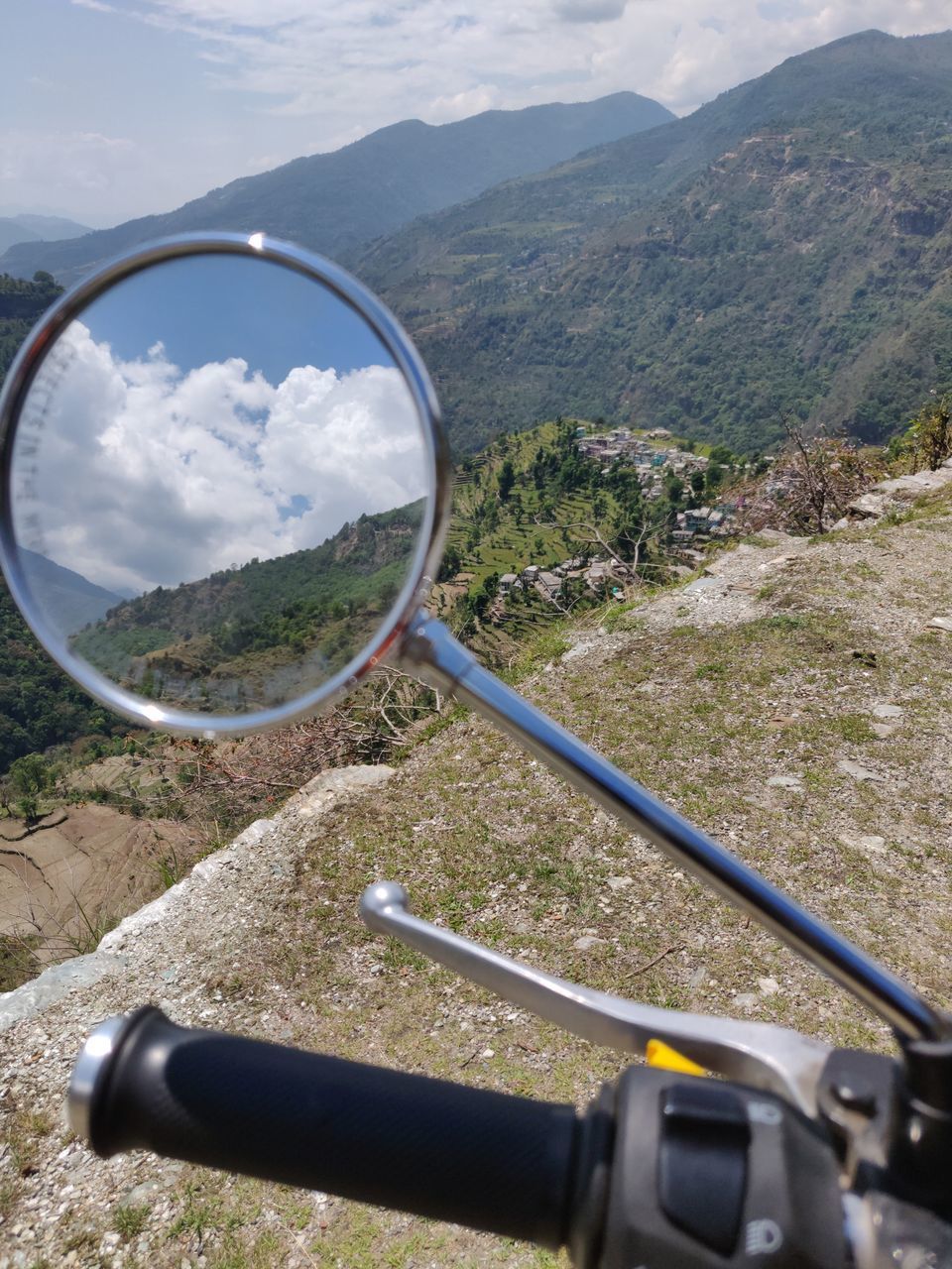 REFLECTION OF MOUNTAINS IN SIDE-VIEW MIRROR OF CAR