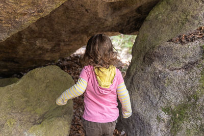 Rear view of woman standing on rock