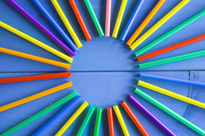 Close-up of colorful drinking straws arranged on wooden table