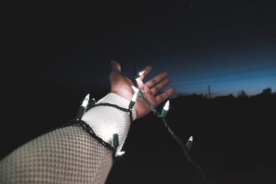 Close-up of woman holding hands against black background